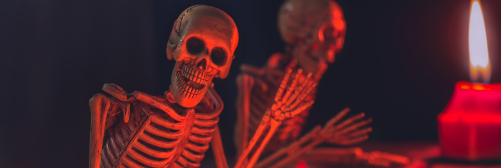 A skeletal figure animatedly moving its hand, with a crimson light highlighting its skull
